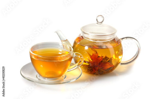 exotic green tea with flowers in glass teapot and cup isolated