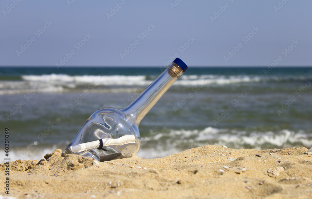 Obraz premium Bottle with a letter on the beach