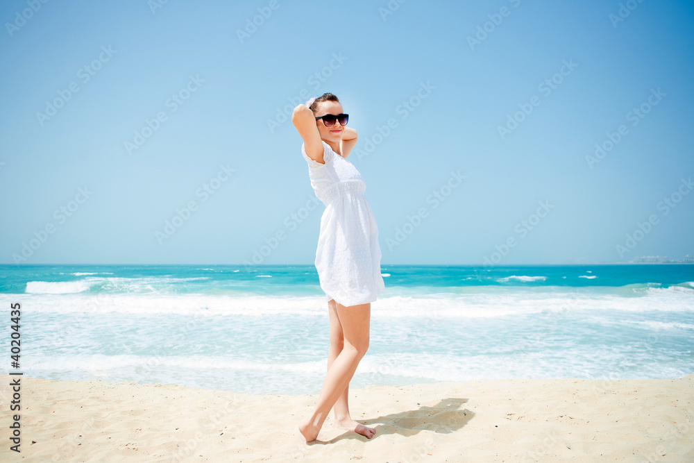 Young beautiful woman posing on the beach
