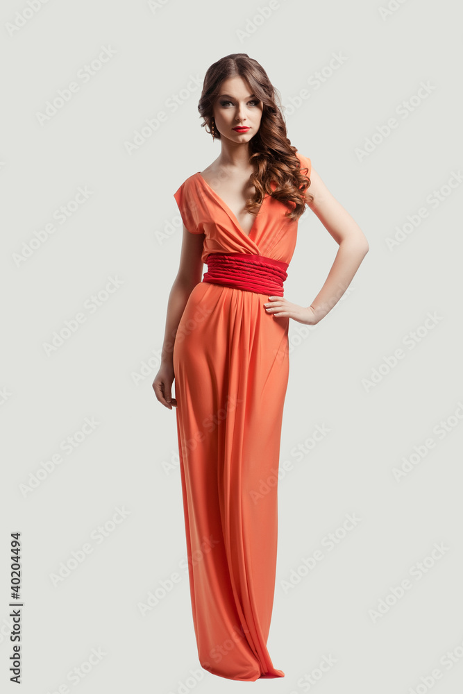 Model with beautiful long hair posing in orange dress Model with beautiful long hair posing in orange dress