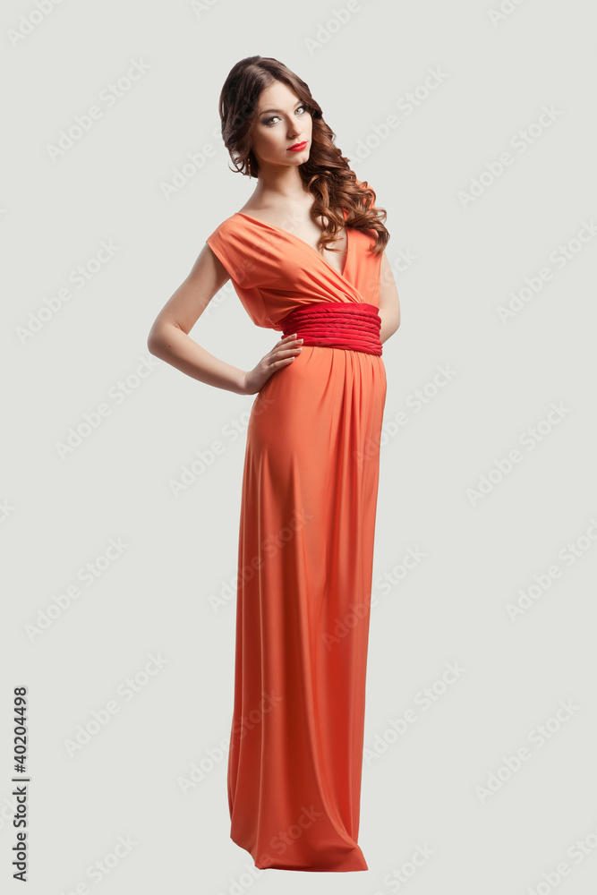 Model with beautiful long hair posing in orange dress Model with beautiful long hair posing in orange dress