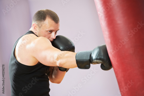 boxer man at boxing training with heavy bag © Kadmy