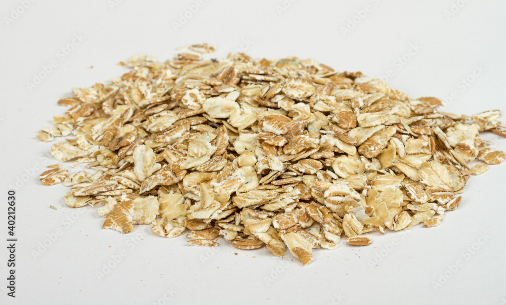 Heap of dry rolled oats isolated on white background