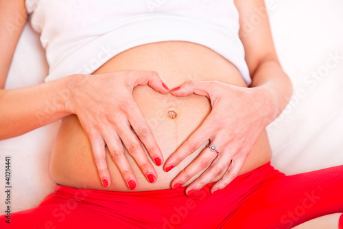 hands in a heart shape on pregnant belly © Aleksandar Todorovic