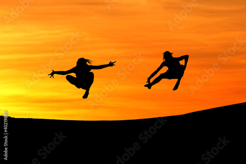 silhouette of friends jumping in sunset for fun