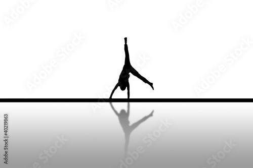 silhouette of gymnast doing cartwheel on floor photo