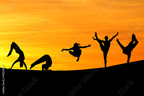silhouette of female gymnasts in sunset