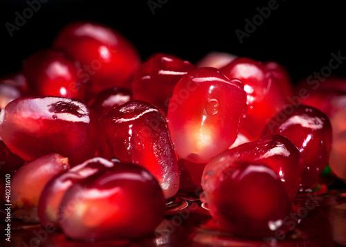 piece of red garnet on a black background with water drops photo