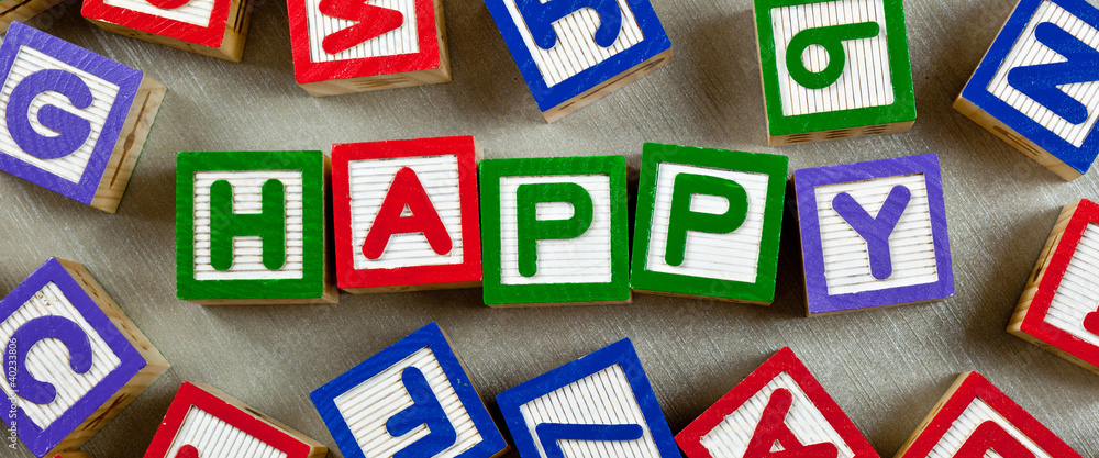 Wooden blocks forming the word HAPPY in the center Wooden blocks forming the word HAPPY in the center