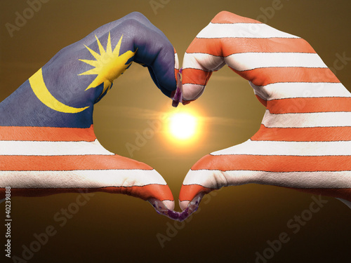 Heart and love gesture by hands colored in malaysia flag during