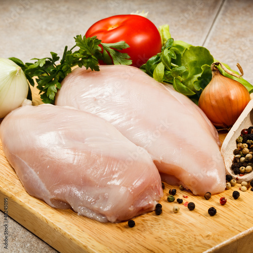 Raw chicken breasts on cutting board
