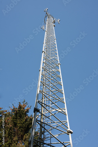Communications tower in the forest with a blue sky