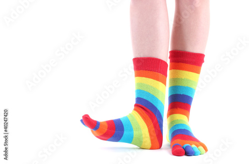 female legs in colorful striped socks isolated on white