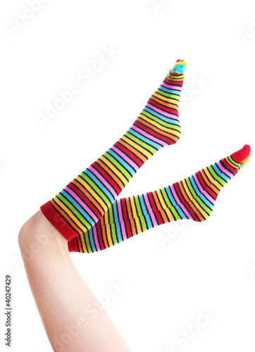 female legs in colorful striped socks isolated on white