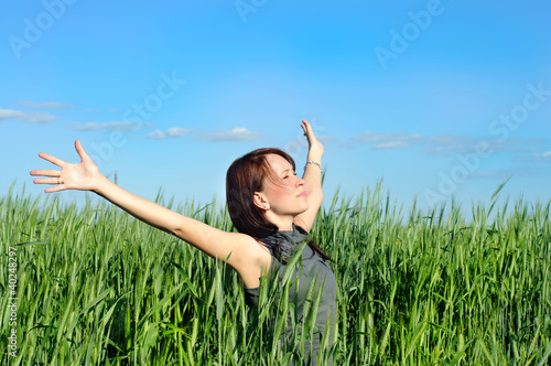 woman with hands raised up in the wheat field