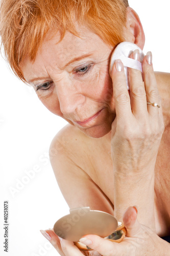 Reife Frau (64) beim Schminken photo