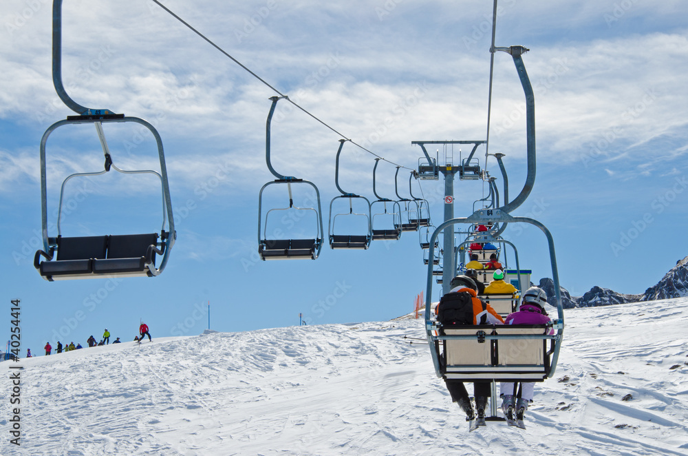 Sessellift in Skigebiet mit Skifahrern über Piste Sessellift in Skigebiet mit Skifahrern über Piste