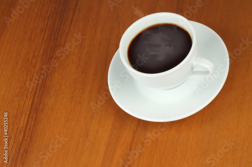 Cup of coffee on a brown wooden background