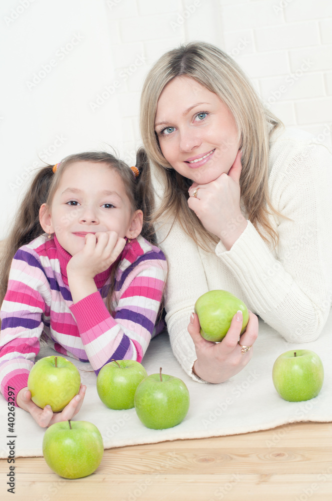 Pretty young woman and her little daughter with green apples Pretty young woman and her little daughter with green apples