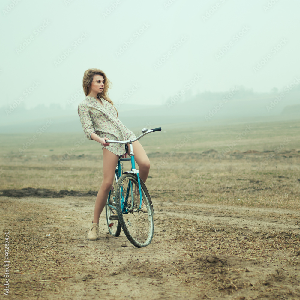 Fototapeta premium beautiful blonde in a dress on a bicycle