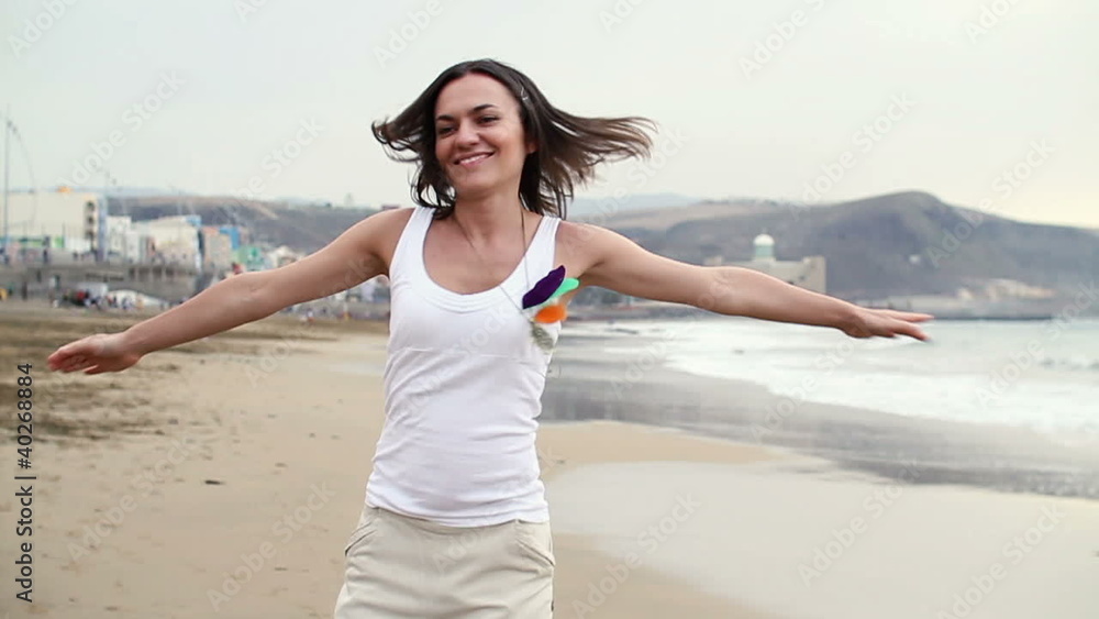 Happy woman running and turning around on beach, slow motion Happy woman running and turning around on beach, slow motion