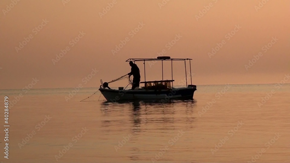 Fisherman getting his net out of the sea Fisherman getting his net out of the sea