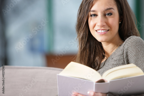 woman lying on couch with book