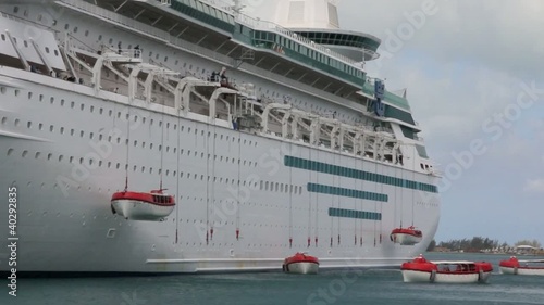 Modern cruise ship deploying lifeboats during a safety drill