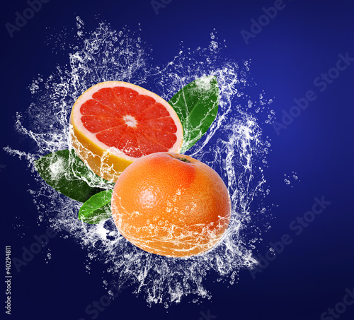Grapefruits wuith leaves in water splahes