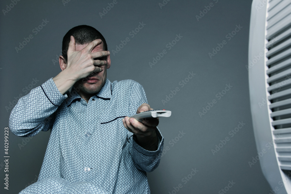 Naklejka premium homme effrayé regardant la télévision en zappant