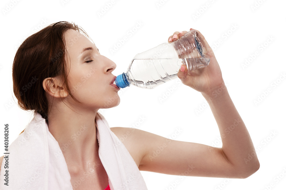 junge sportlerin trinkt wasser vor weißem hintergrund junge sportlerin trinkt wasser vor weißem hintergrund