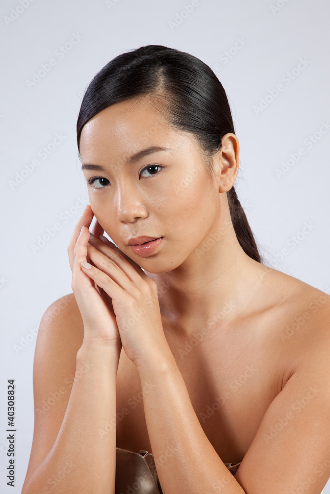 Pretty Asian woman with hands by face