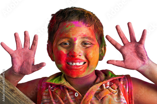 Close up face of young boy playing Holi, smiling with colors on photo