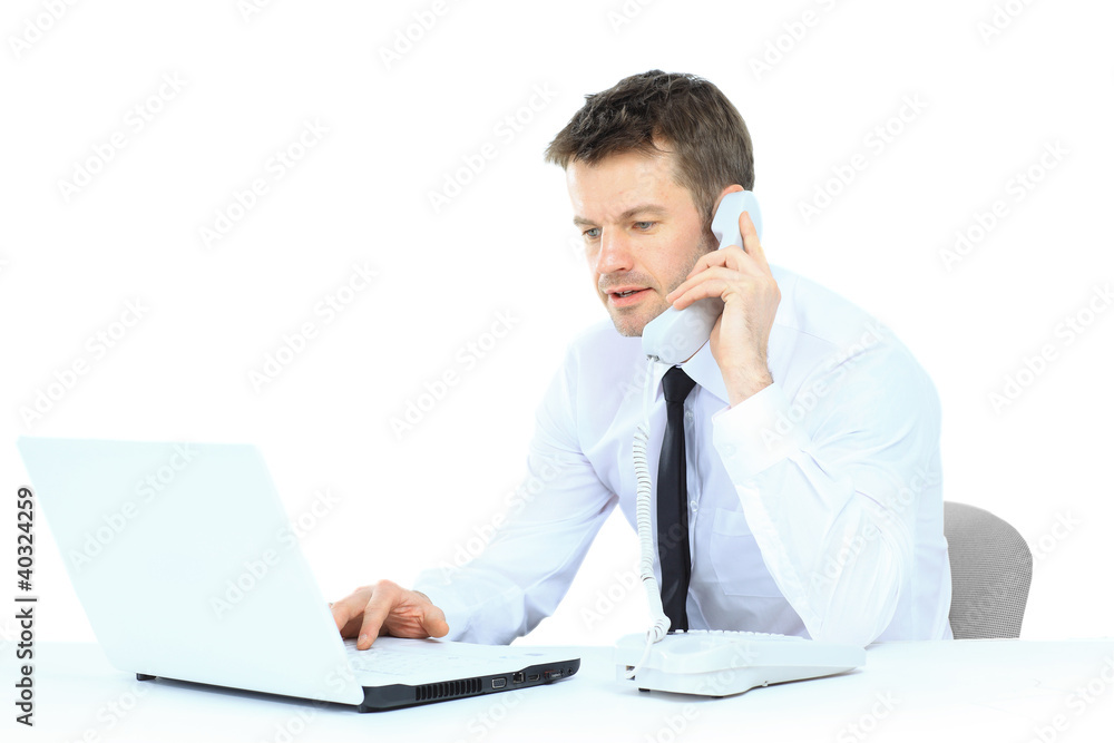Happy business man on cell phone in front of laptop Happy business man on cell phone in front of laptop