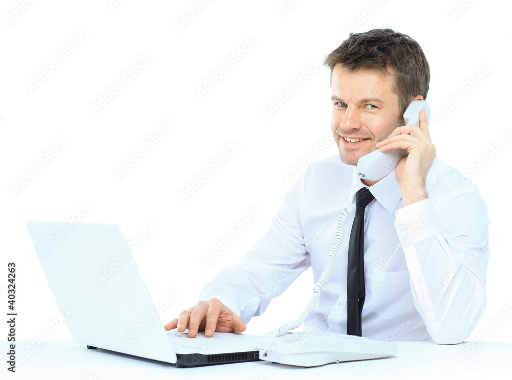 Happy business man on cell phone in front of laptop Happy business man on cell phone in front of laptop