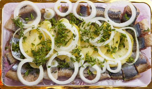 Snack from a herring with a potato and onions