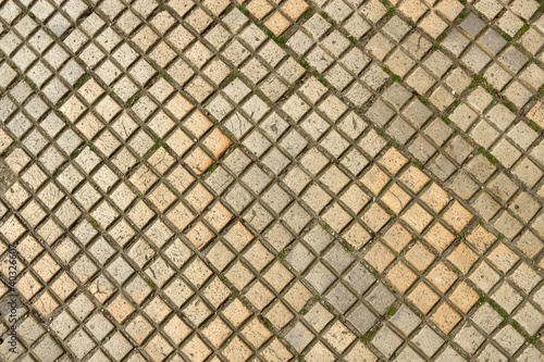 Dirty old square shapes paving slabs close up.