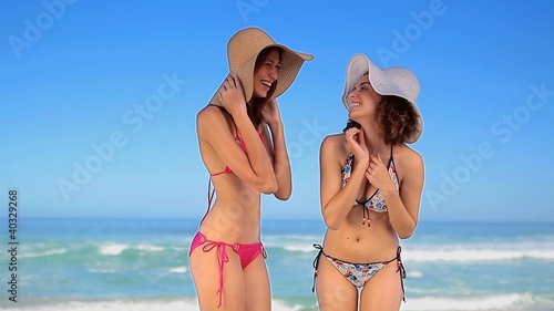 Happy women standing while wearing straw hats