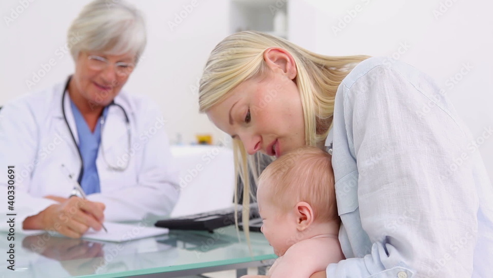 Smiling blonde woman holding her baby Smiling blonde woman holding her baby