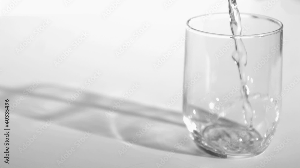 Trickle of water in a super slow motion flowing into a glass Trickle of water in a super slow motion flowing into a glass