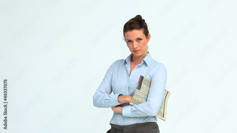 Woman reads a newspaper and crosses her arms Woman reads a newspaper and crosses her arms