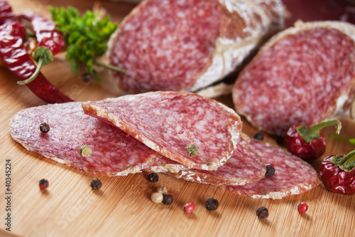 Sliced salami on wooden board