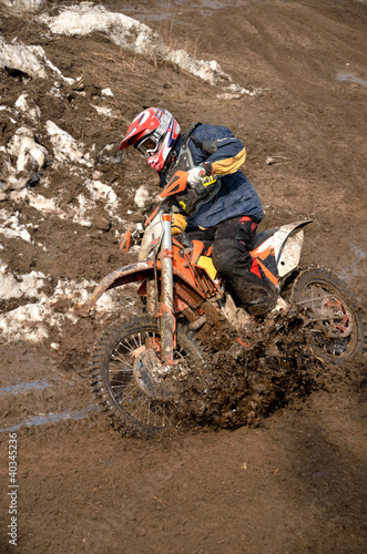 Motocross racer is turning in gauge line with a spray of dirt