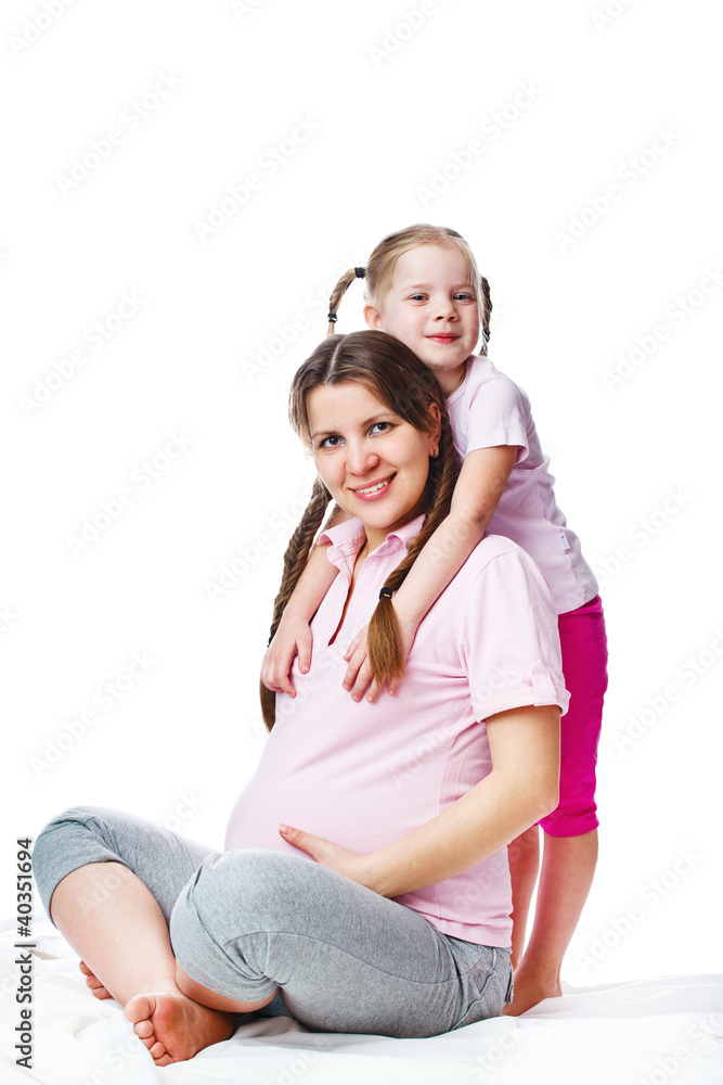 Beautiful pregnant woman with her daughter. Isolated on white Beautiful pregnant woman with her daughter. Isolated on white