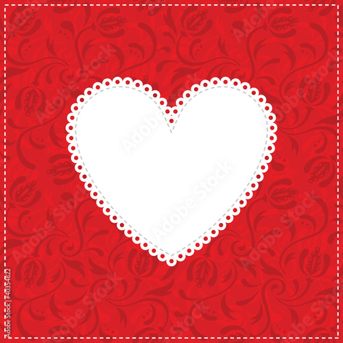 White lacy heart on red ornamental background.