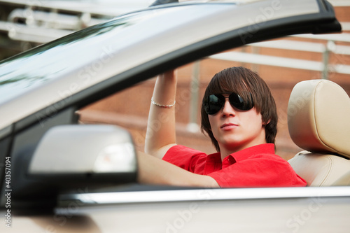 Young man driving a convertible car © Wrangler