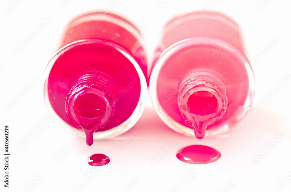 couple of red and pink nailpolish bottles on white couple of red and pink nailpolish bottles on white