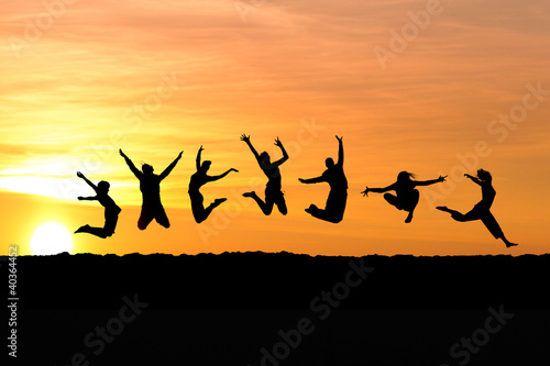 group jumping in sunset at beach