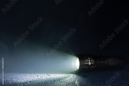 Tactical waterproof flashlight with waterdrops and smoke photo
