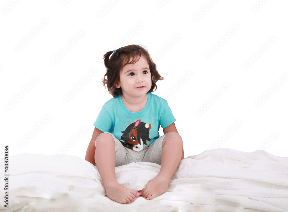 Curly toddler girl in bed, looking into camera Curly toddler girl in bed, looking into camera